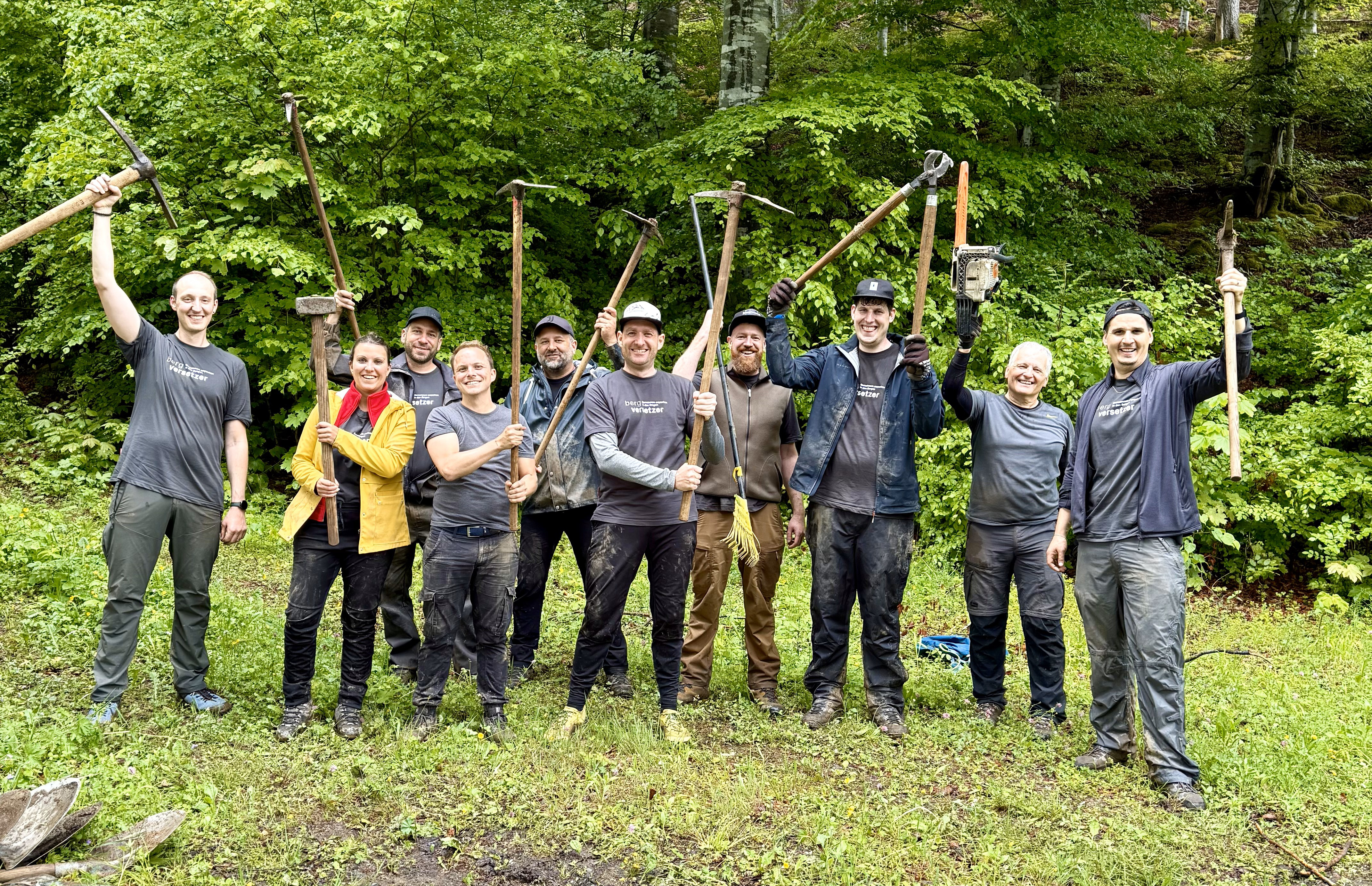 Gruppenfoto von neun Männern und einer Frau im Wald